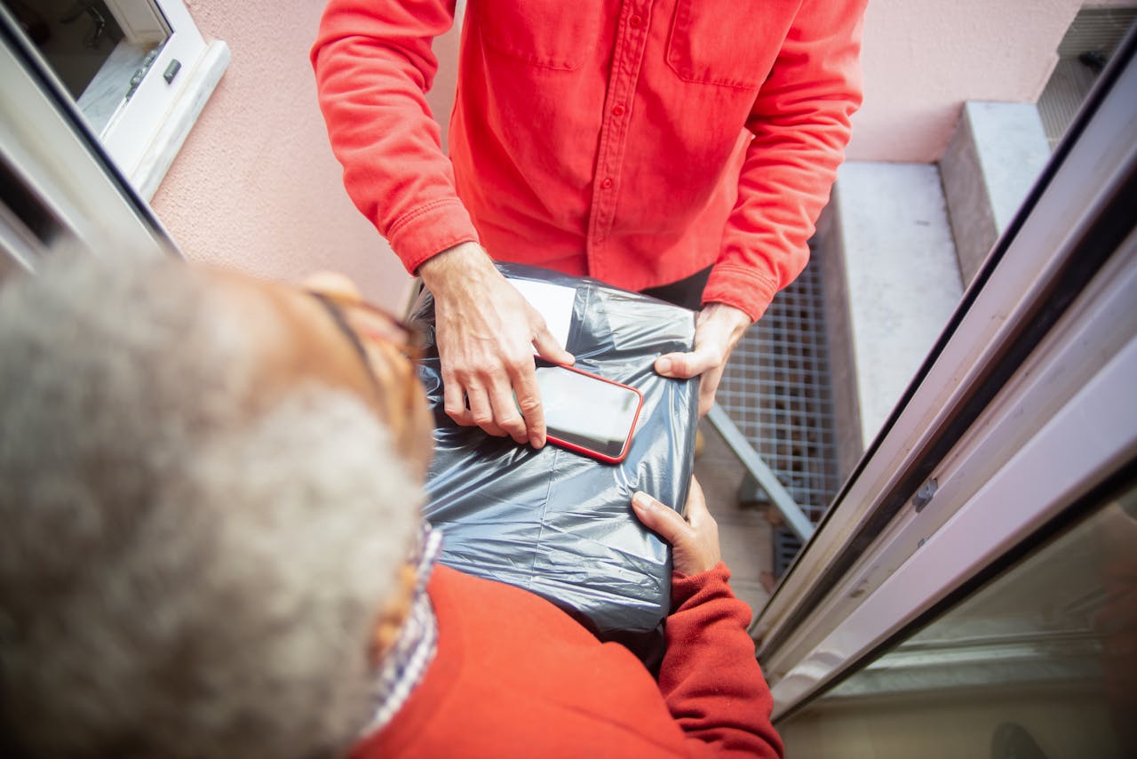 High angle shot of courier delivering a package to a customer at their doorstep.